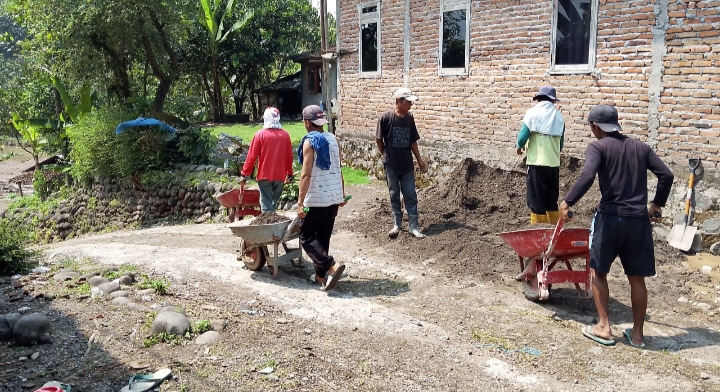 Keterangan foto: Warga Desa Bolo bergotong royong mengangkut material pembangunan Jembatan Gantung Garuda dengan gerobak dorong.