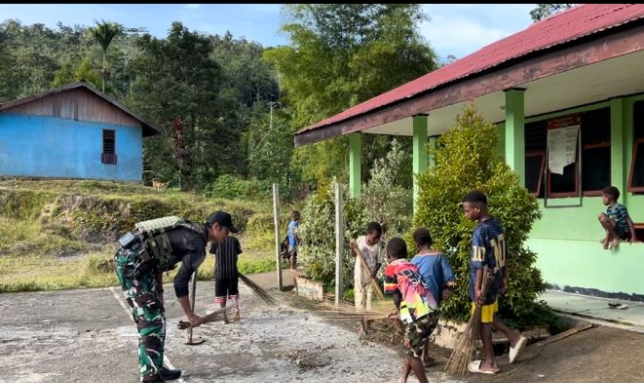 Satgas Yonif 763/SBA bersama siswa SD Inpres 82 Bamusbama bergotong royong membersihkan lingkungan sekolah.