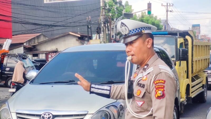 Petugas Ditlantas Polda Riau mengatur arus lalu lintas di SPBU Pekanbaru guna mengantisipasi antrean BBM dan kemacetan.