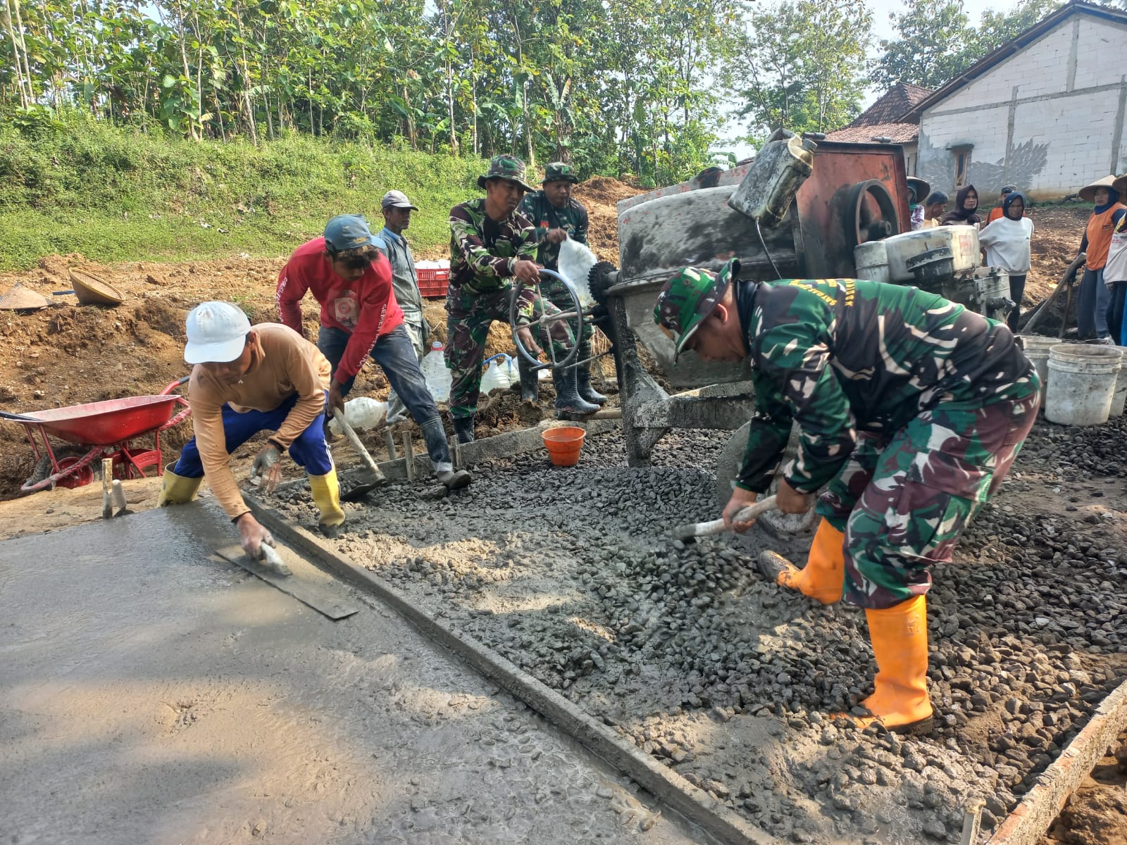 Anggota TNI bersama warga bergotong royong mengecor jalan Desa Kauman, Boyolali.