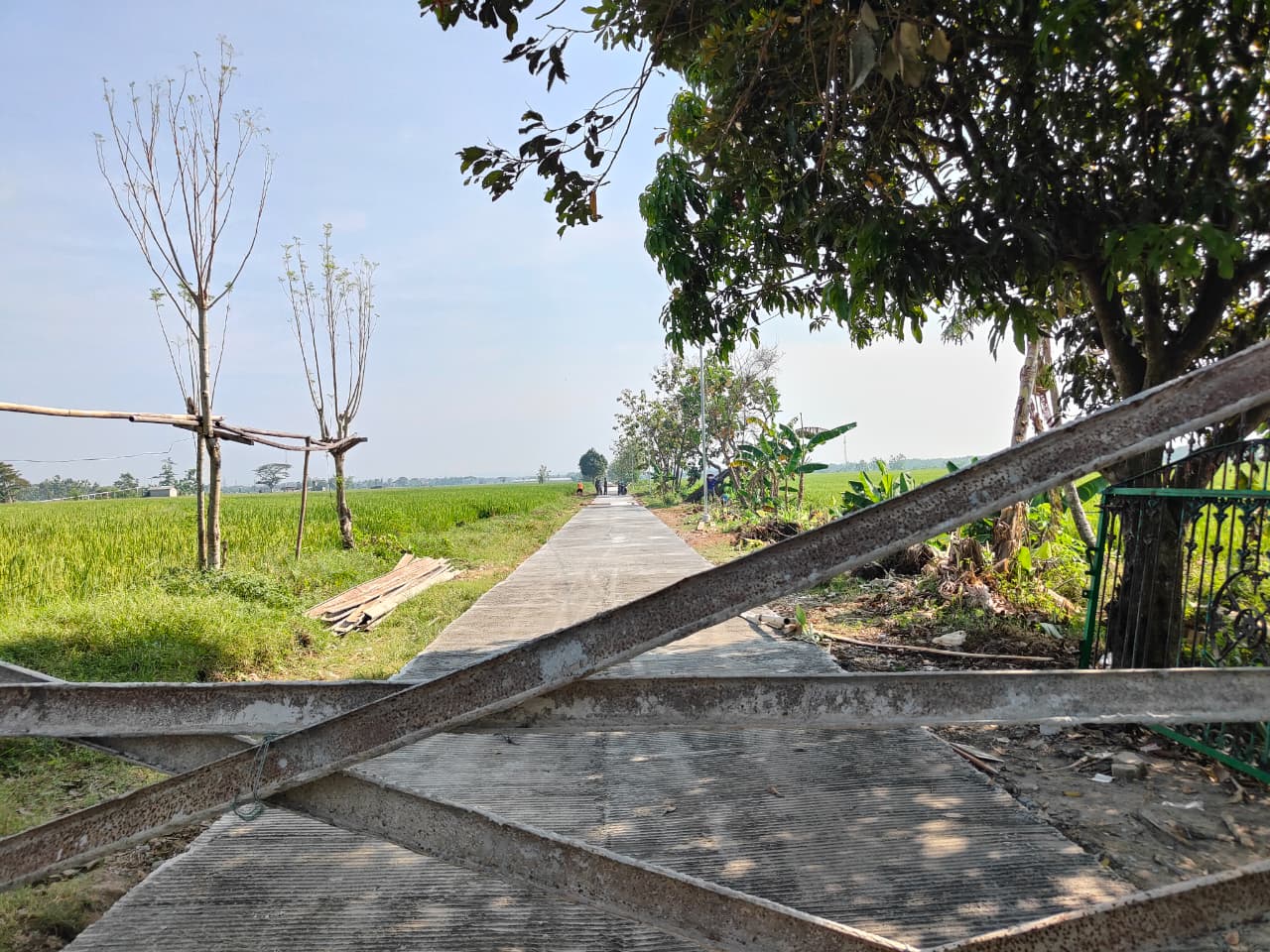 Warga Desa Puro menjaga jalan cor TMMD yang masih dalam proses pengeringan.